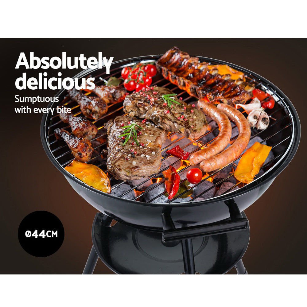 Grill with various meats and vegetables on a dark background