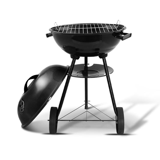 Black charcoal grill with lid on a white background