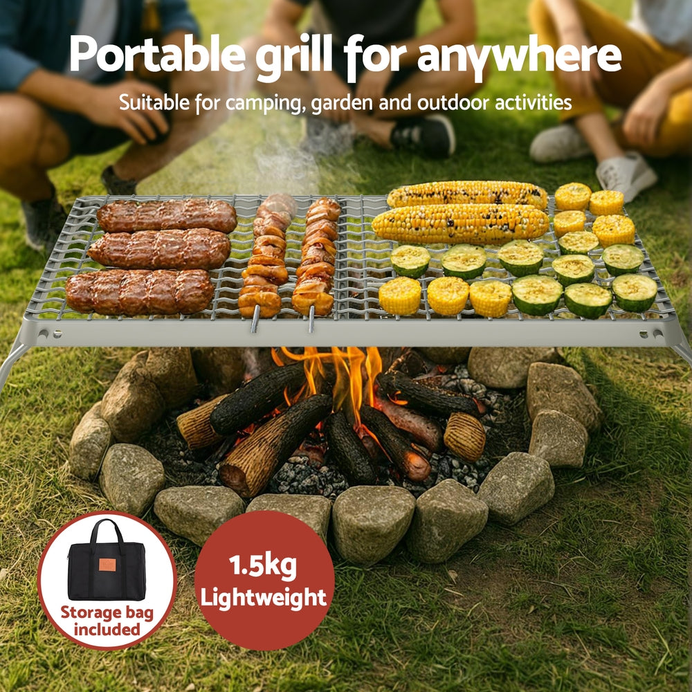 Portable grill being used outdoors with food on a fire pit, suitable for camping and garden activities.