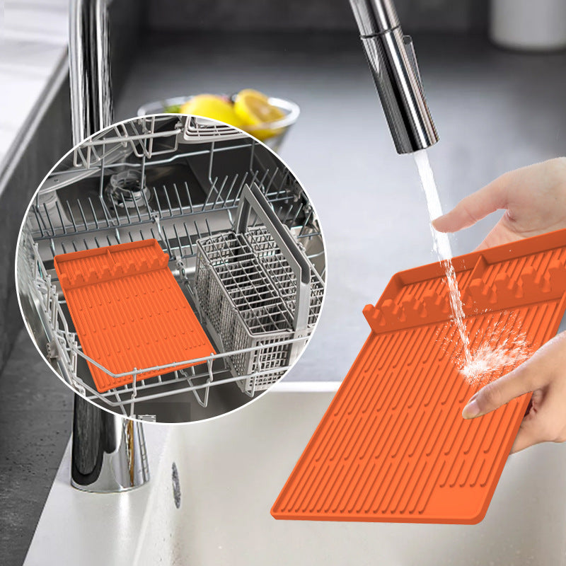Orange cutting board being rinsed under a faucet with a close-up of a dishwasher rack.