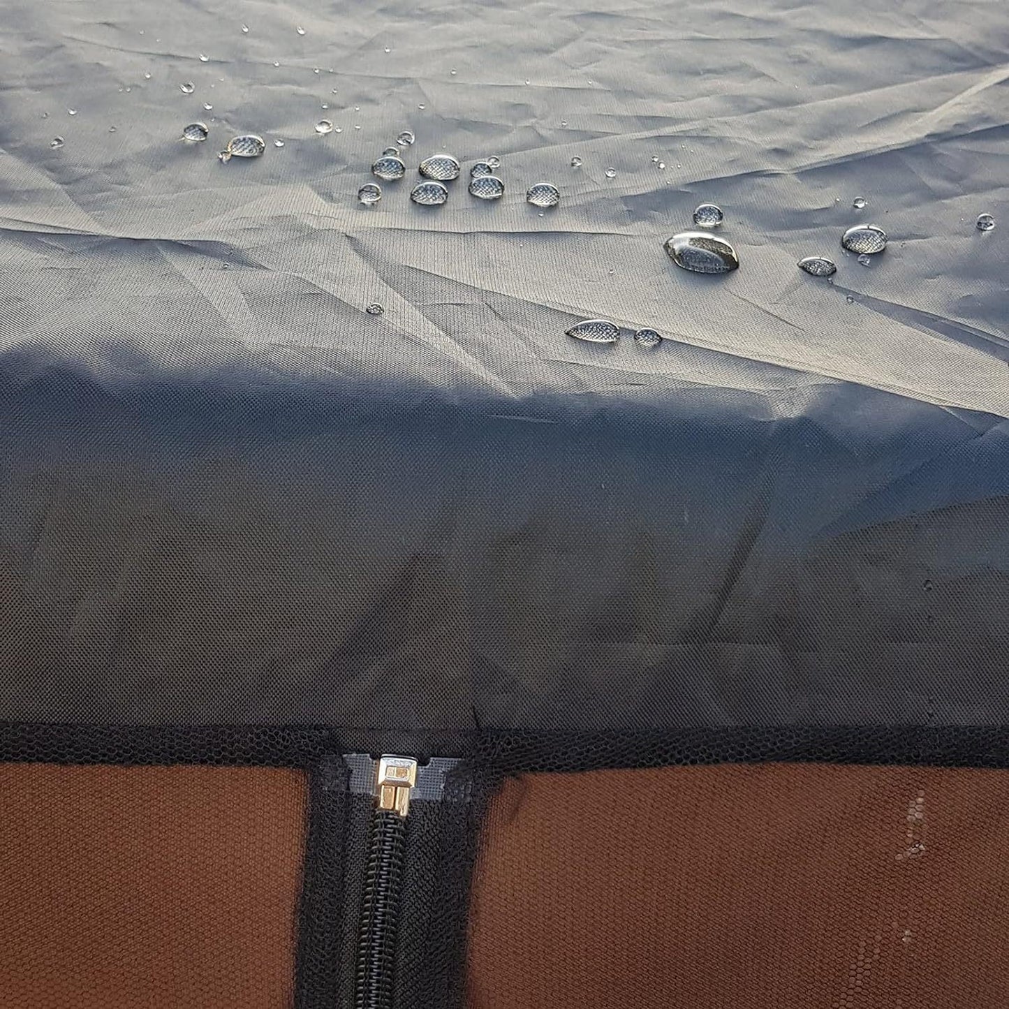 Water droplets on a waterproof fabric with a zipper, showing water-resistant properties.